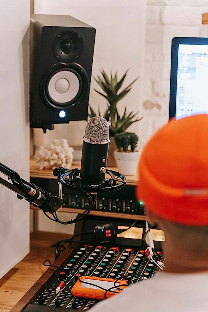 contact-img A well-equipped recording studio featuring a condenser microphone, mixer, and speakers.