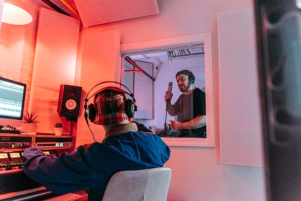 why-choose-us Audio engineer and singer collaborating in a modern recording studio environment.